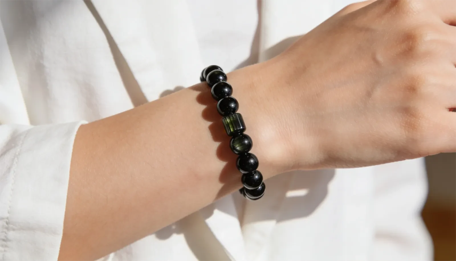 Cổ tay đeo vòng tourmaline đen với trang phục trung tính hằng ngày
