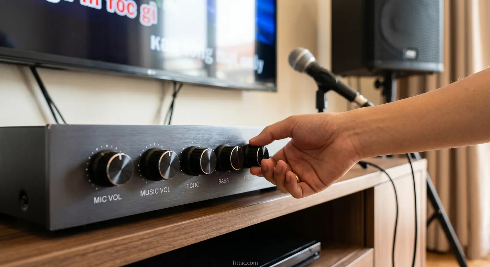 Close-up of karaoke mixer controls for mic volume, music volume, echo, bass, and treble