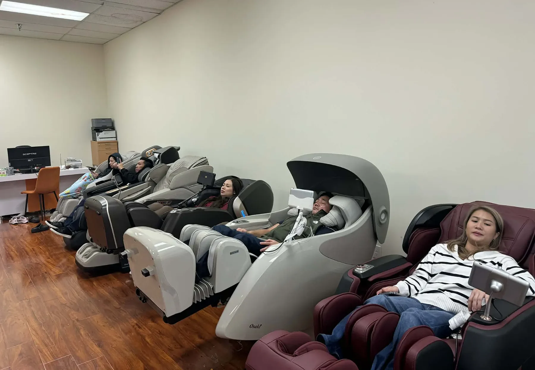 People testing massage chairs at Tittac’s Garden Grove showroom in Orange County